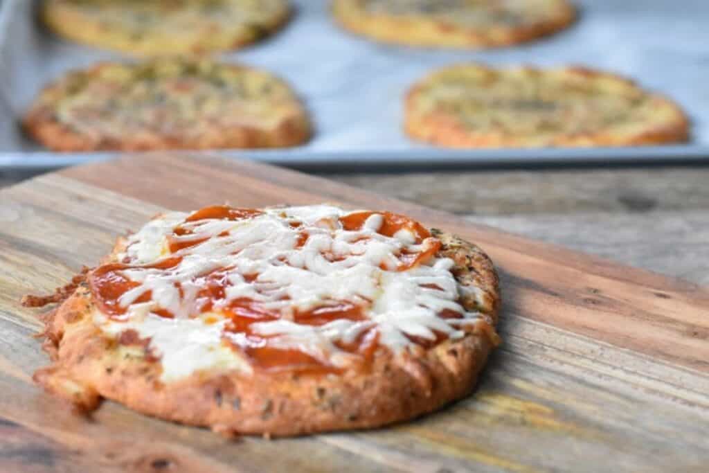 A pizza is sitting on top of a wooden cutting board.