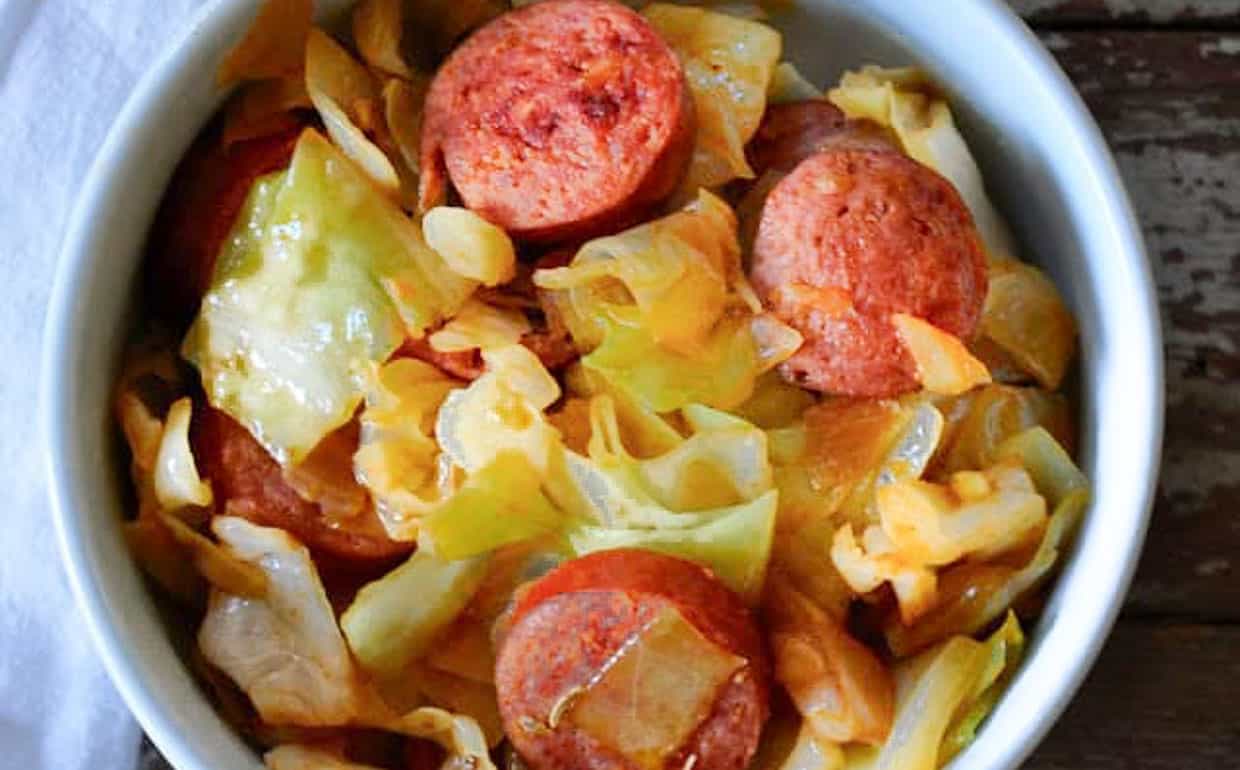 A bowl of cabbage and sausage.