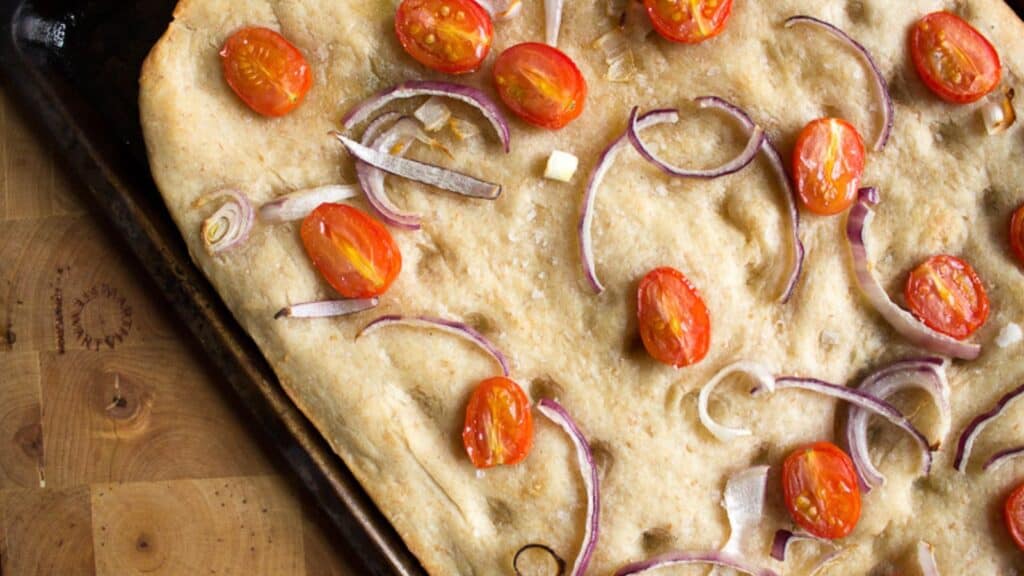 Focaccia on a wooden cutting board.