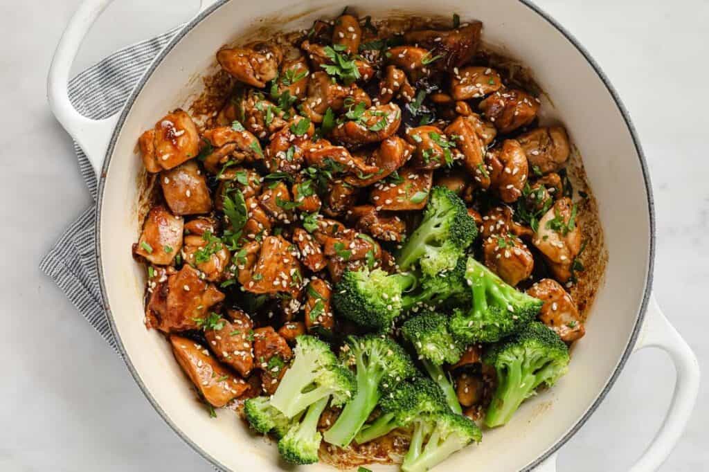 Chicken and broccoli in a pan with sesame seeds.