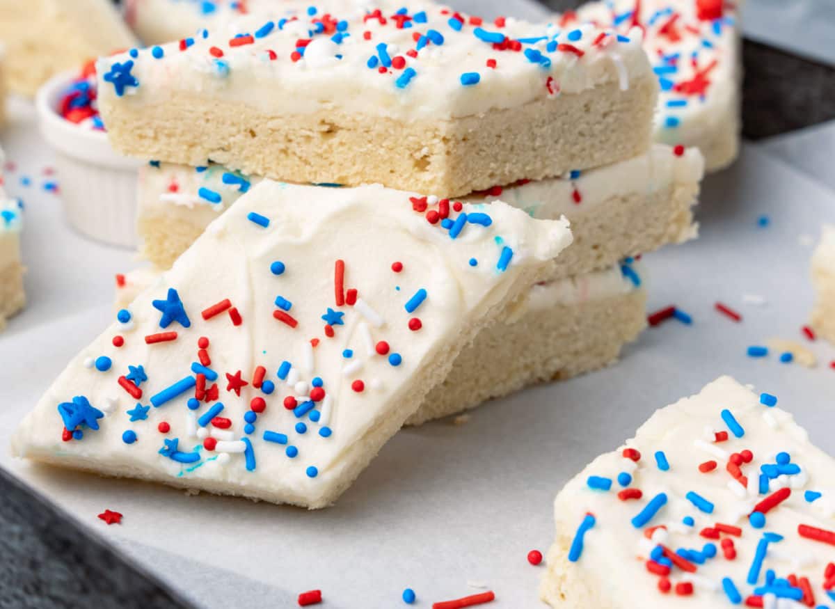 Red, white and blue sugar cookies stacked on a white plate.