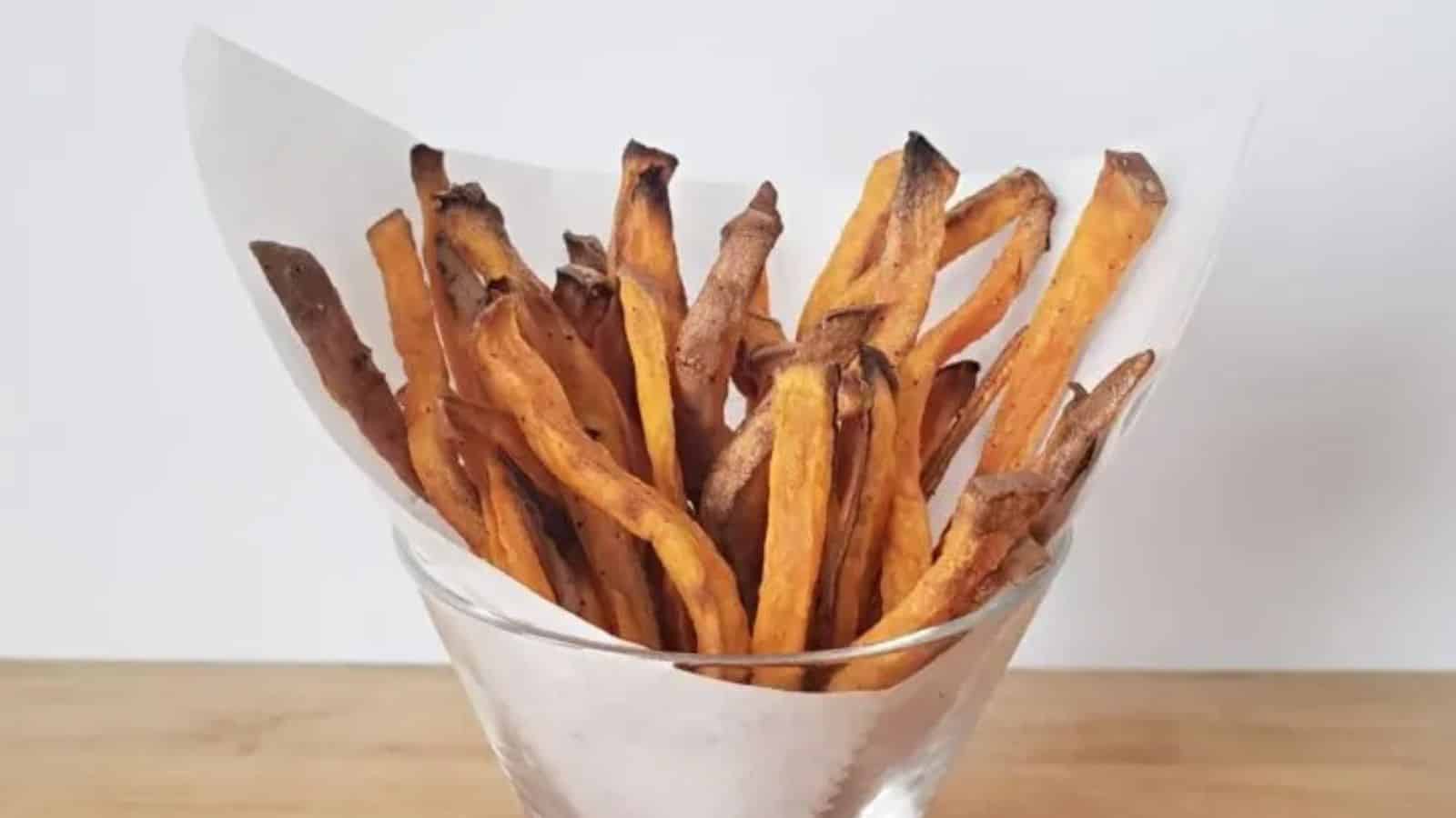 Image shows a glass filled with Sweet Potato Fries.