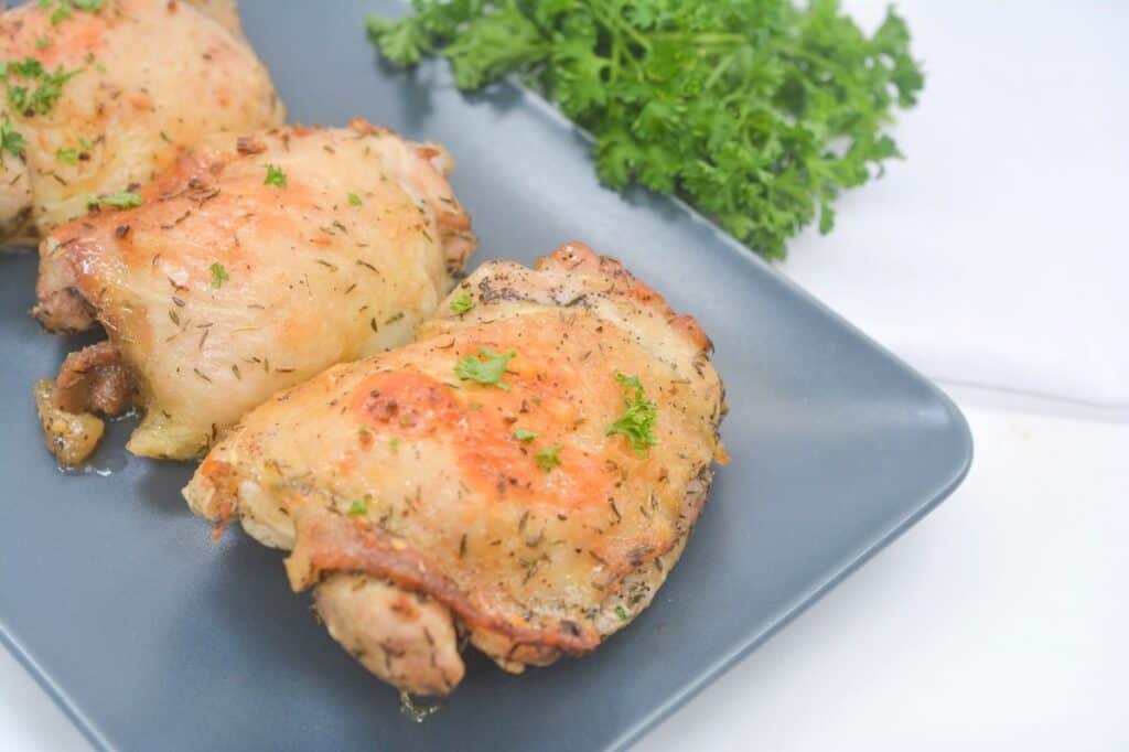 Chicken thighs on a plate with parsley.