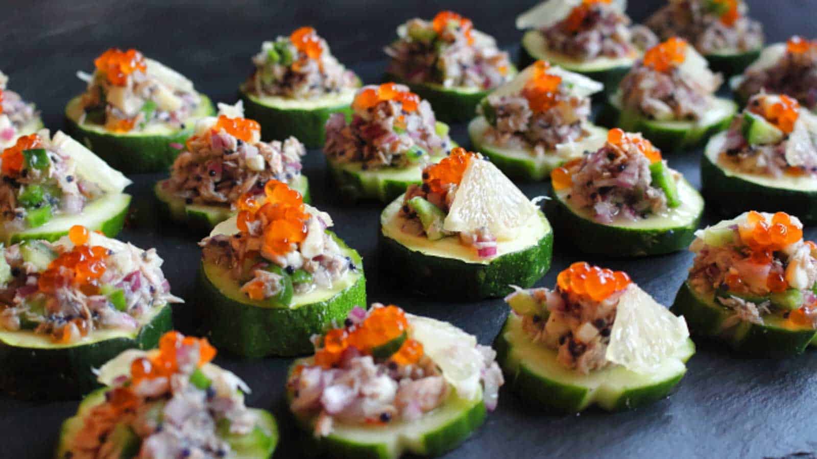 A tray of easy appetizers with tuna and cucumbers.