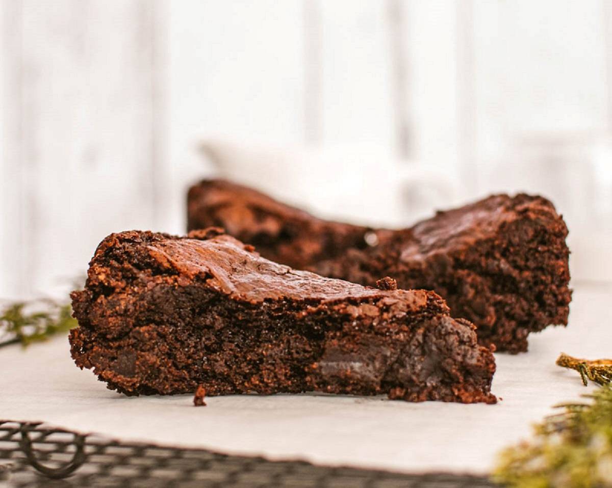 A piece of chocolate brownie sitting on a cooling rack.