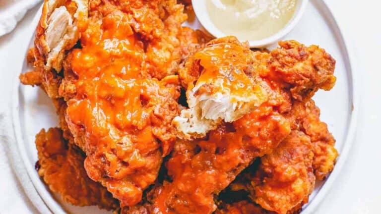 Fried chicken wings on a plate with dipping sauce.