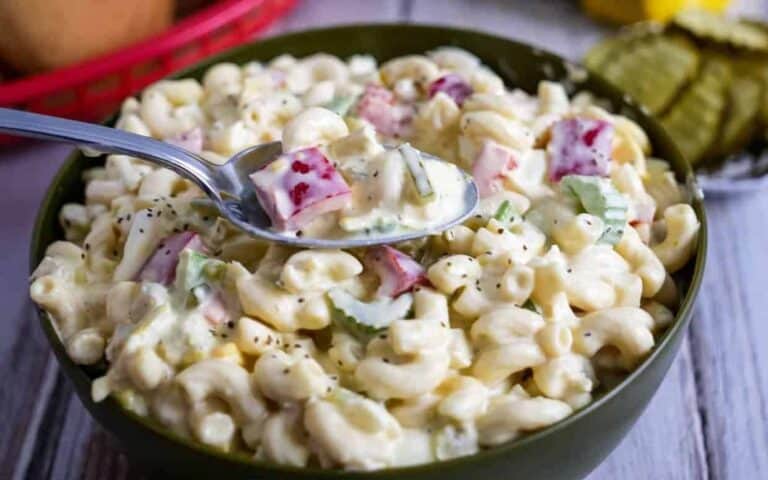 Macaroni salad in a bowl with a spoon.