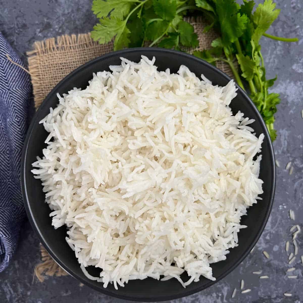 Cooked basmati rice placed in a black bowl.