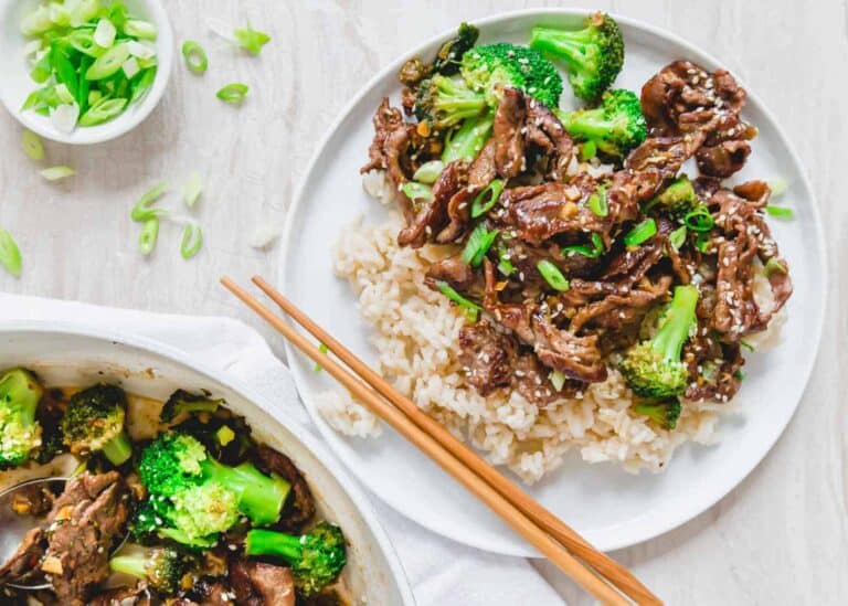 Beef and broccoli stir fry with rice and chopsticks.