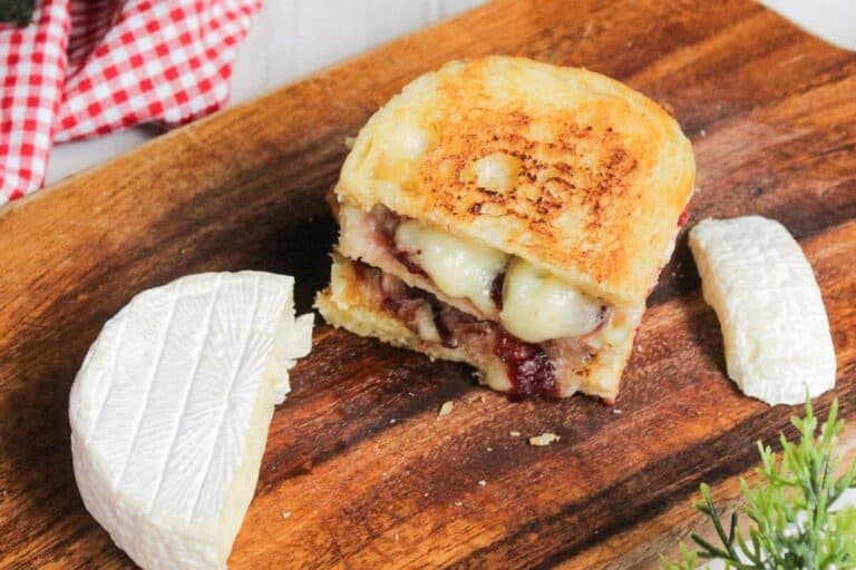 A grilled cheese sandwich on a wooden cutting board.