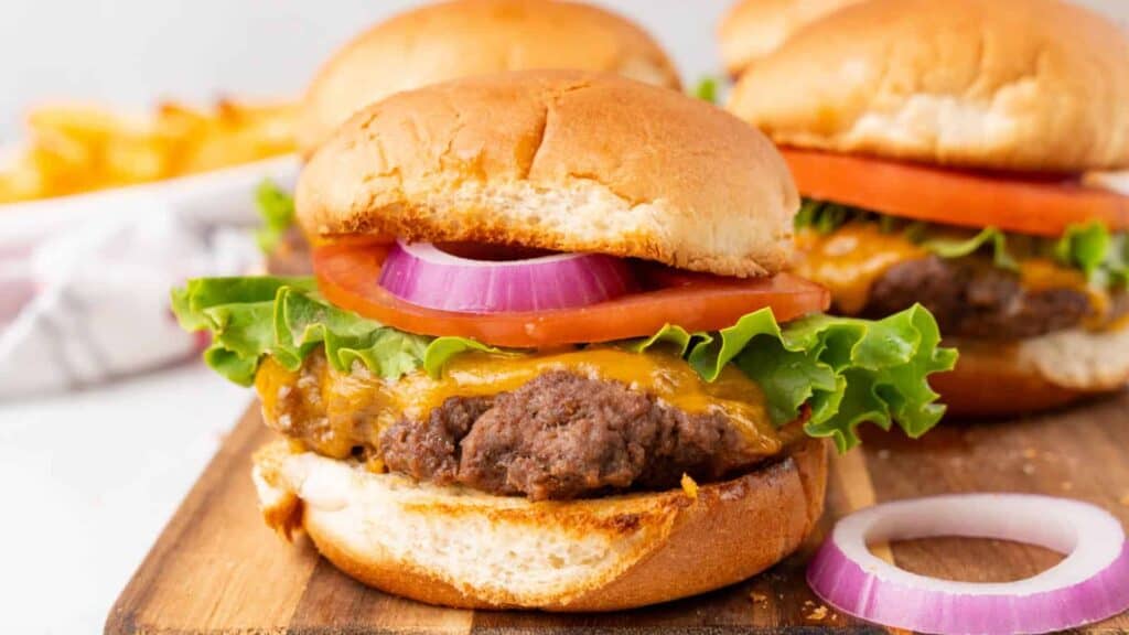 Hamburger sliders on a wooden cutting board.