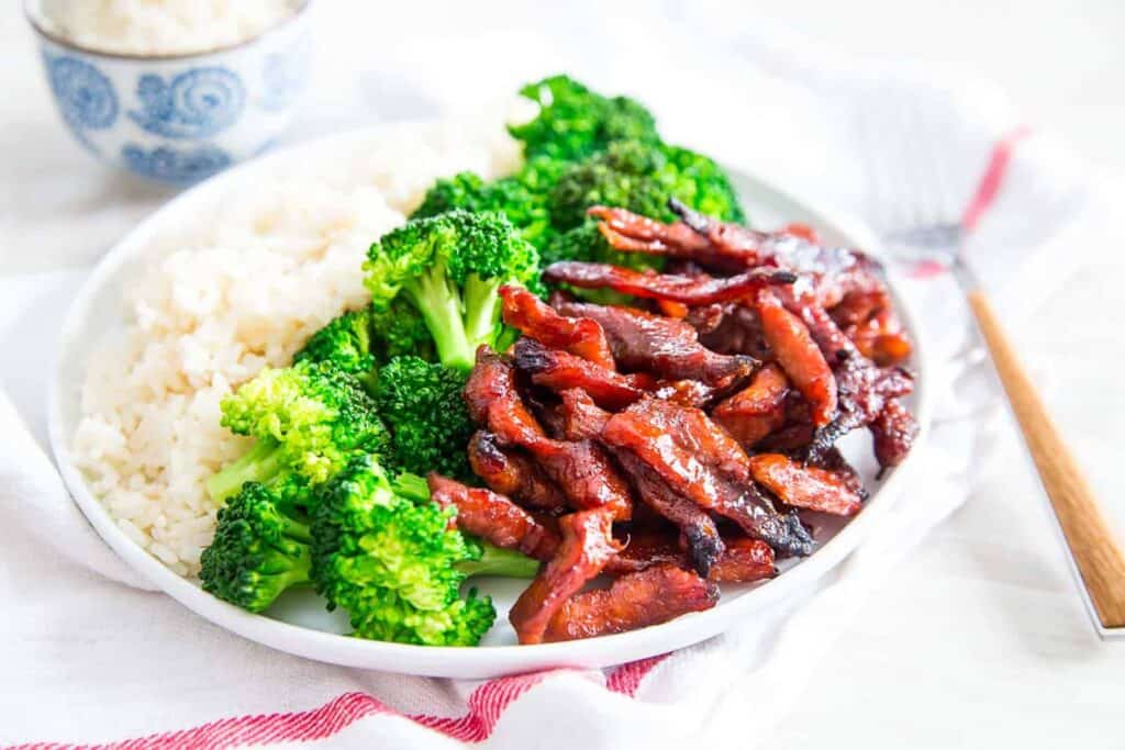 Homemade Chinese spare ribs with broccoli and rice on a white plate.