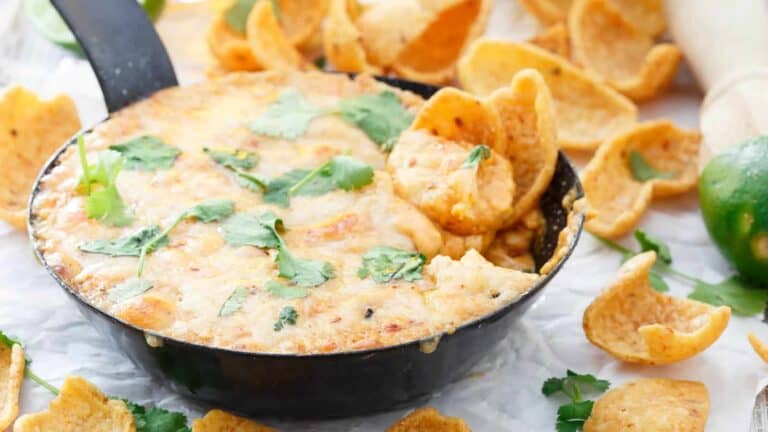 Mexican fundido dip in a black skillet with tortilla chips.