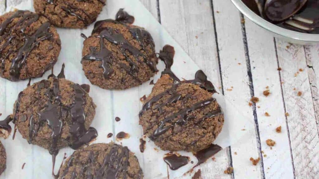 Gluten free cookies dipped in chocolate on a wooden board.
