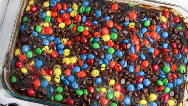 A baking dish filled with chocolate cake with m & m's.
