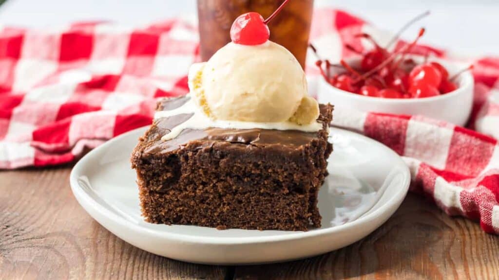 A piece of chocolate cake with ice cream on a plate.