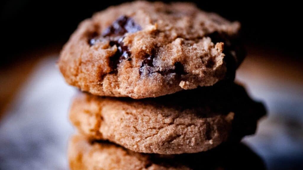 A stack of gluten-free chocolate chip cookies on top of a piece of paper.