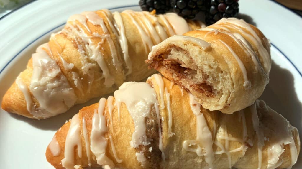 Cinnamon crescent rolls on a white plate.