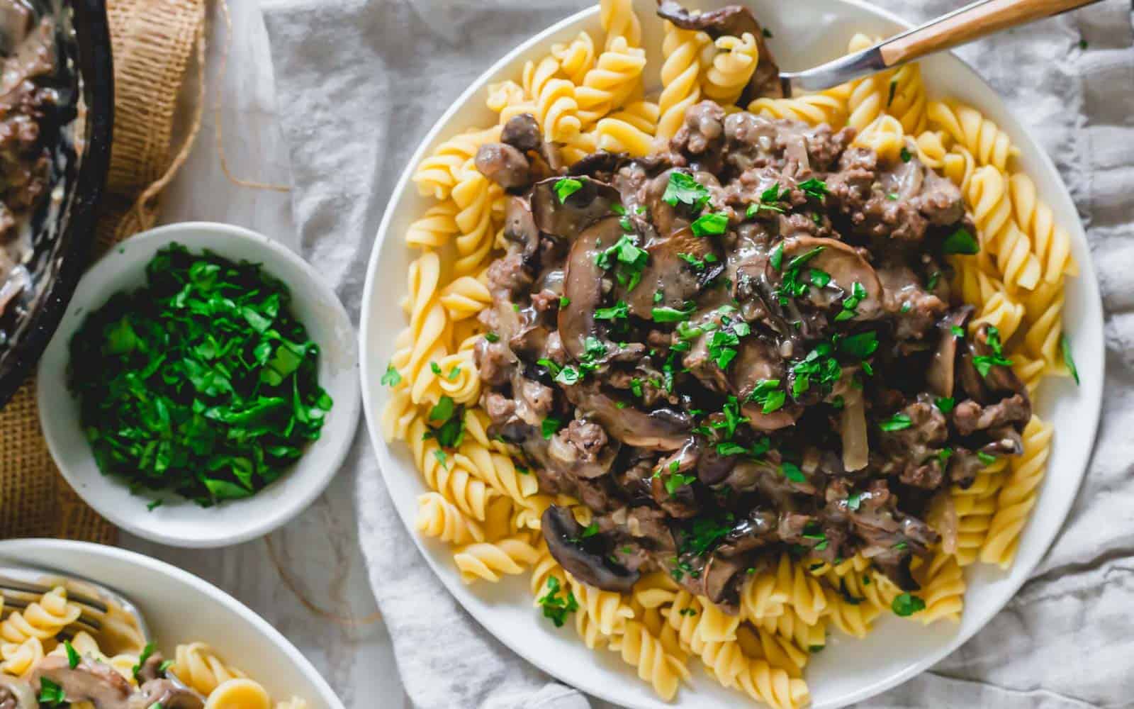 Dairy-free venison stroganoff over pasta garnished with parsley.