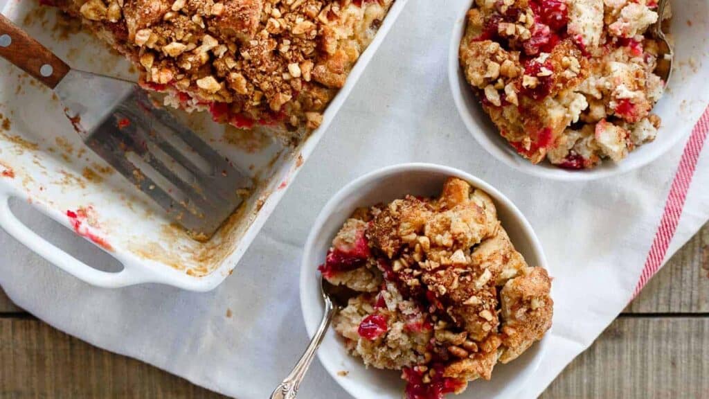 Cranberry crumb cobbler in a white dish with a fork.