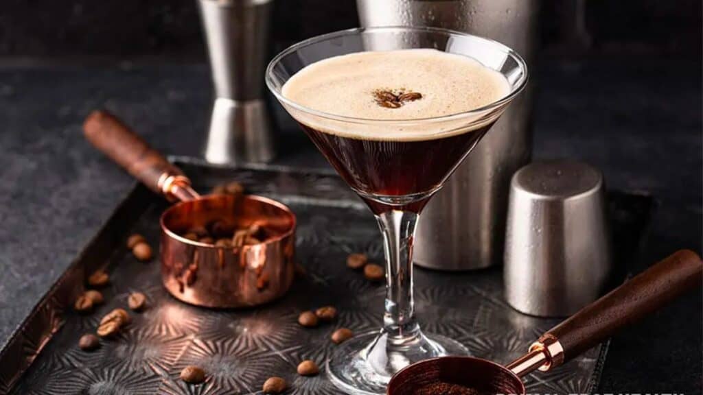 A martini glass filled with coffee and coffee beans.