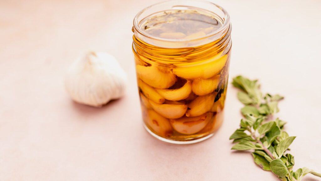 A jar of pickled garlic on a table.