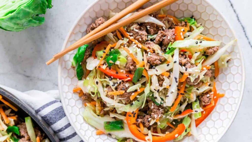 A bowl of asian stir fry with meat and vegetables.