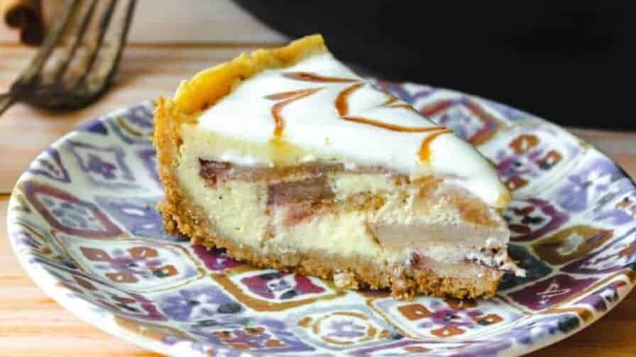 Slice of apple pie cheesecake in front of the Instant Pot.