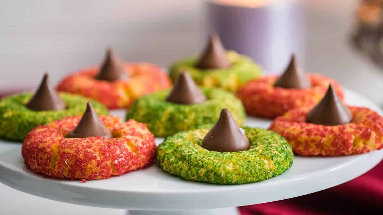 Air fryer kiss cookies on a plate with sprinkles.