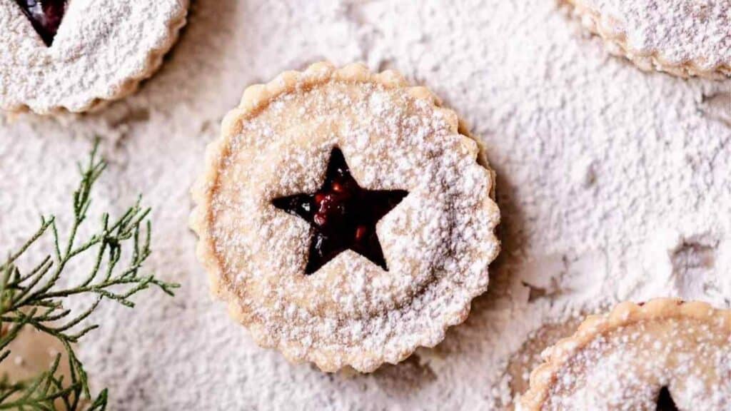A group of gluten-free berry pies with powdered sugar and a star on top.