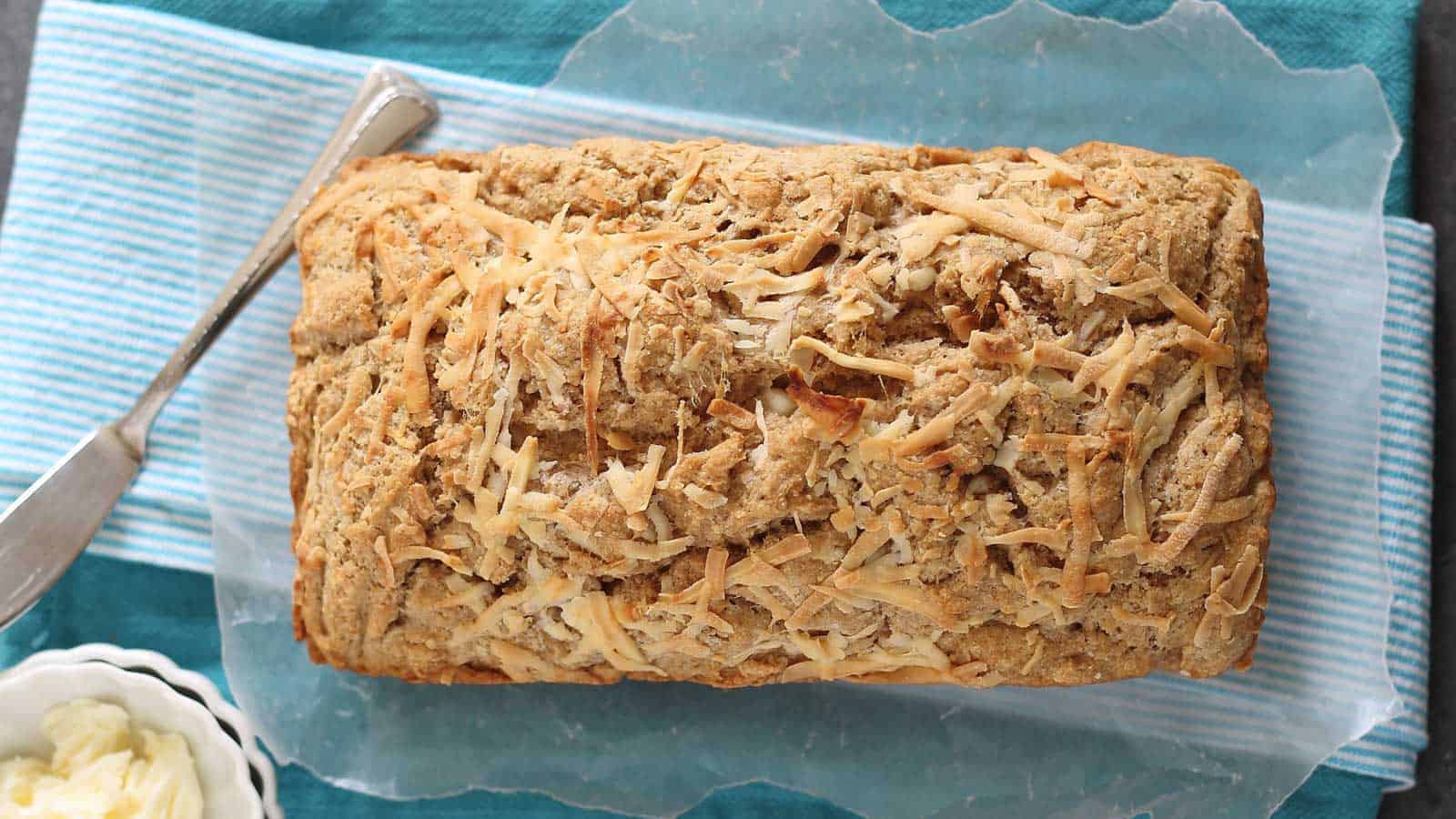 Maple parmesan beer bread loaf on a blue kitchen towel.