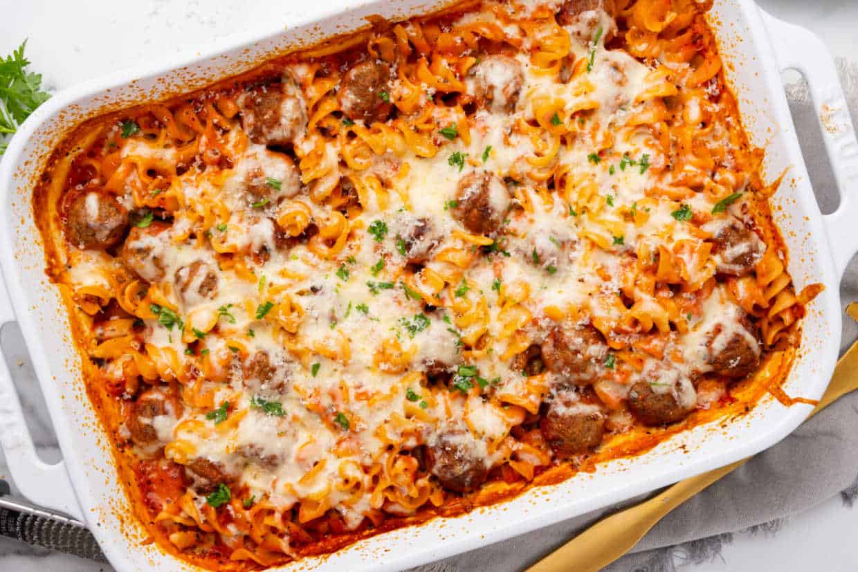 A casserole dish filled with meatballs and cheese.