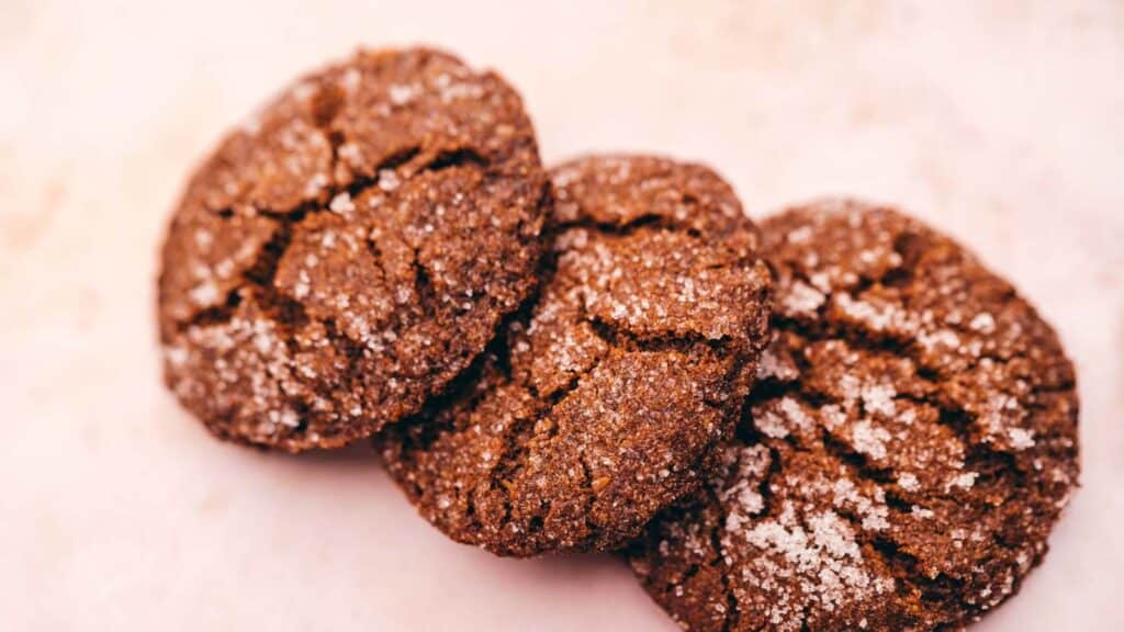 A close up of three gluten free chocolate cookies with powdered sugar.
