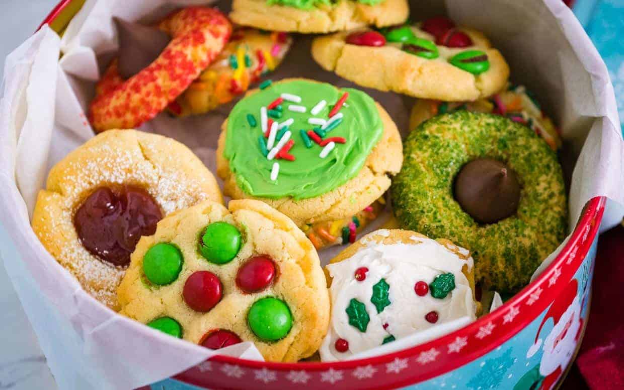 Air fryer christmas cookies in a metal cookie tine with different decorations.