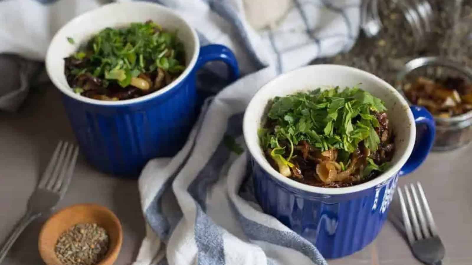 Two blue mugs filled with vegetables and herbs.