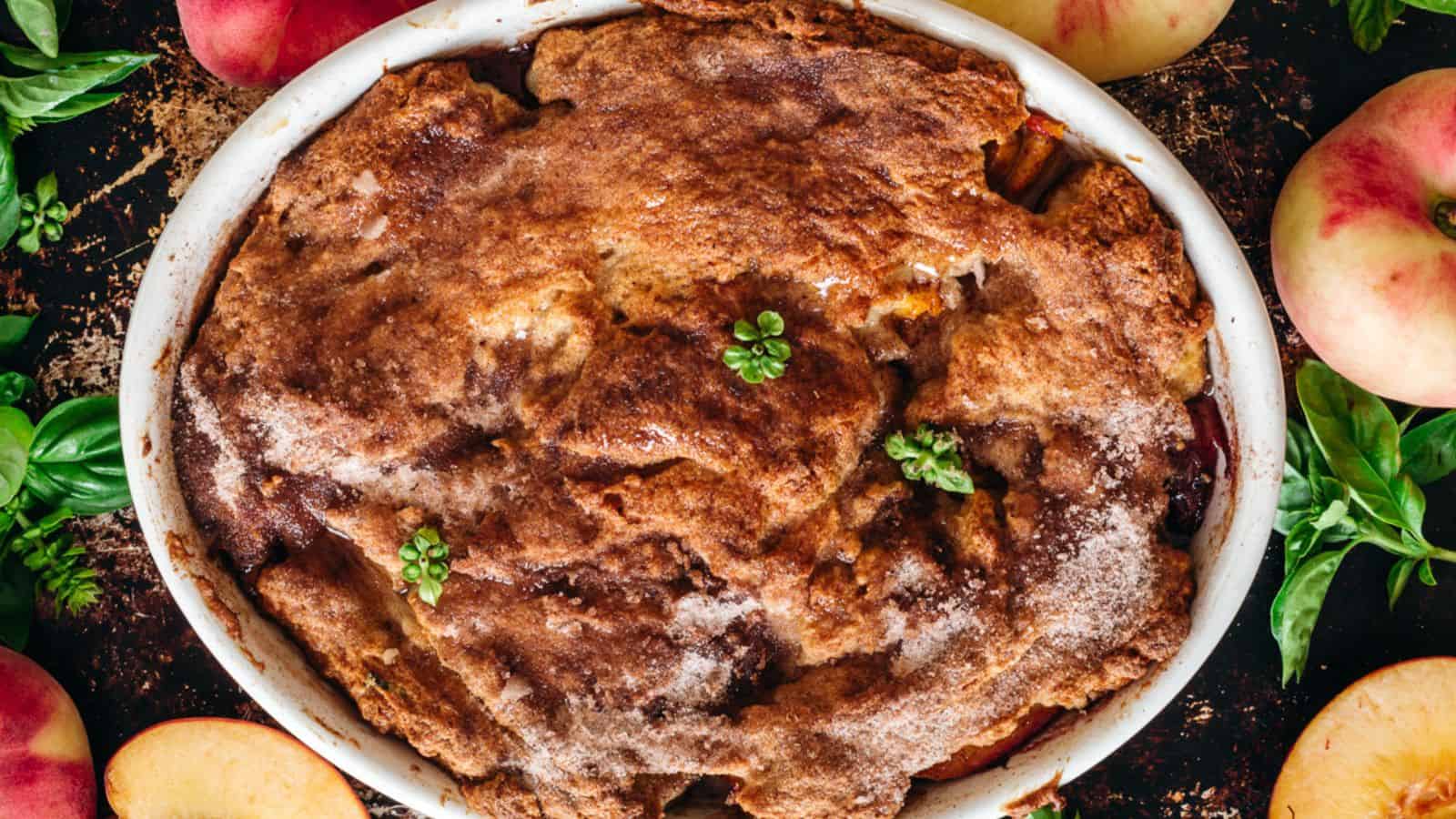 A fruit pie with apples and herbs on a wooden table.