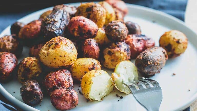 Roasted potatoes on a plate with a fork.