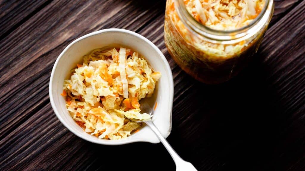 Sauerkraut in a jar on a wooden table.