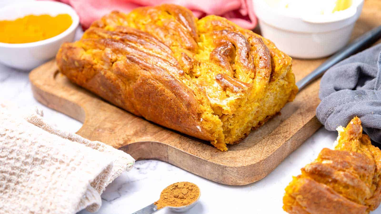 A loaf of pumpkin bread on a cutting board.