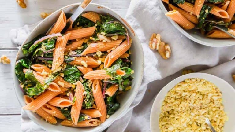 A bowl of pasta with kale and walnuts.