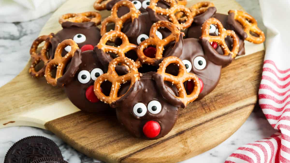 Chocolate reindeer cookies on a cutting board.