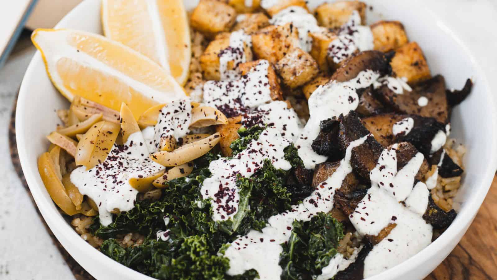 A bowl with kale, mushrooms and dressing.