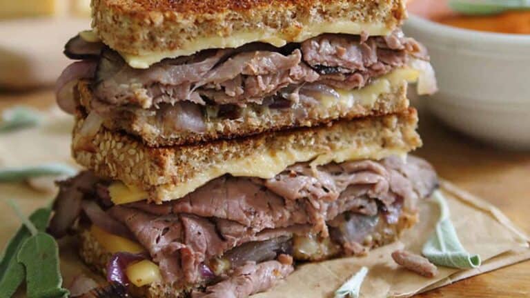 A grilled sandwich with meat and cheese on top.