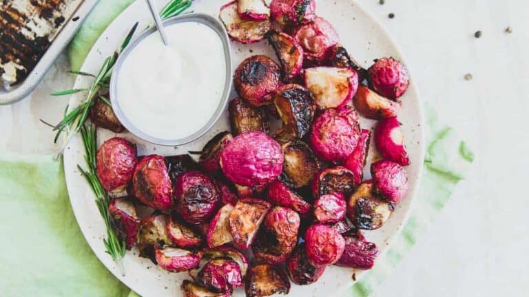 Roasted radishes with sour cream on a plate.