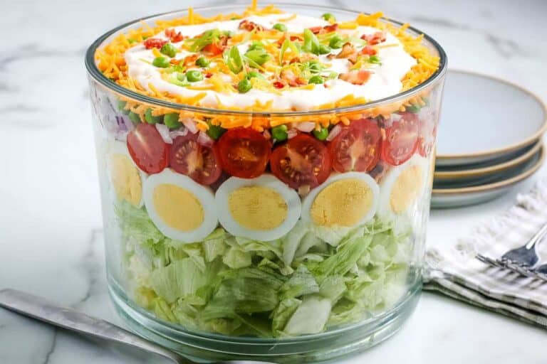 A salad in a glass bowl with eggs and tomatoes.