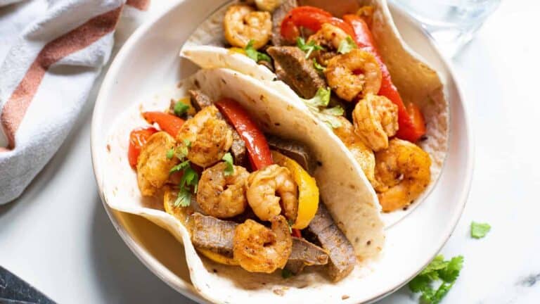 Tacos with shrimp and peppers on a plate.