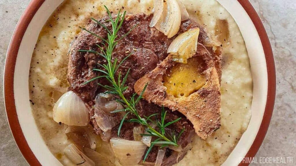 A picture of an easy beef shank slow cooker recipe over cauliflower mash with rosemary.