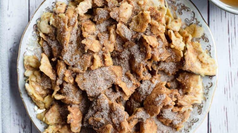 A plate of cinnamon raisin crisps with a cup of tea.