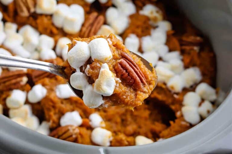 A spoonful of sweet potato casserole with marshmallows and pecans.