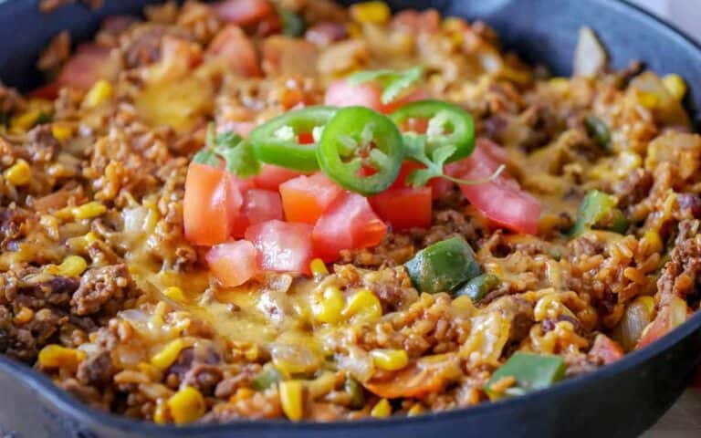 Mexican rice in a skillet with tomatoes and peppers.